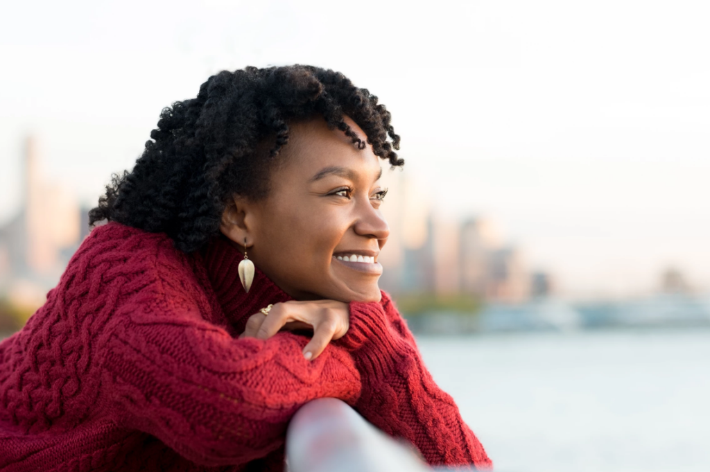 Pretty black American lady smiling while looking into sun
